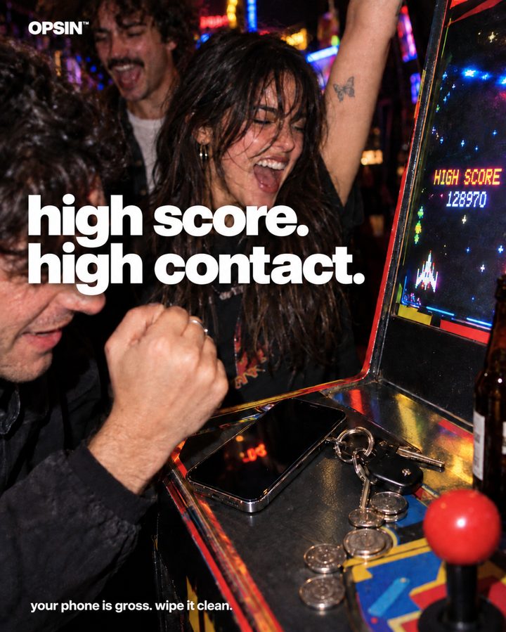 Friends at an arcade cabinet with a phone